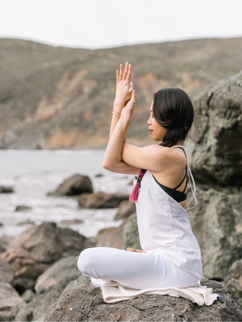 A woman meditating near the sea